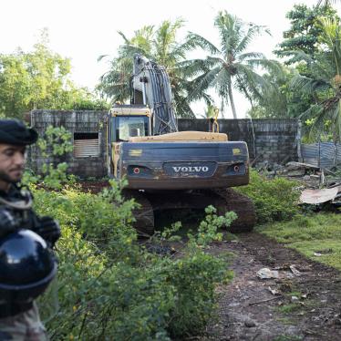 A French gendarme stands guard during the demolition of an informal settlement in Longoni, Mamoudzou, on the island of Mayotte.