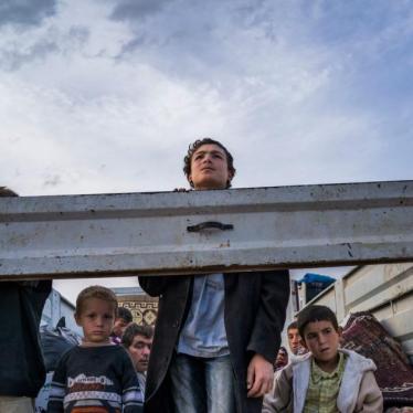 2014年9月。叙利亚库德族难民在卡车上向外张望，他们正由叙利亚北部城镇科巴尼（艾因阿拉伯）及附近村庄进入土耳其。