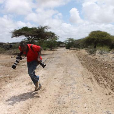 Somali photojournalist runs for cover while reporting on fighting between the Somali government and African Union forces against the Islamist armed group Al-Shabab in the Lower Shabelle region of Somalia, April 2012. 