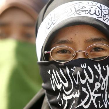 A masked member of the Islamic group Hizbut Tahrir Indonesia takes part in a rally in Makassar, South Sulawesi, November 1, 2009.