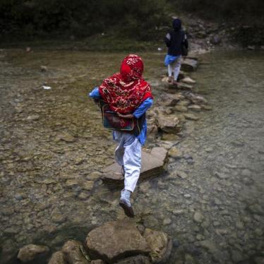 A girl crosses a stream as she walks to school in Margalla Hills, Islamabad, October 24, 2014.