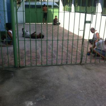 A group of persons with disabilities in a yard in an institution in Rio de Janeiro. Residents are taken outside for a few hours during the day but spend most of the time confined to their beds.